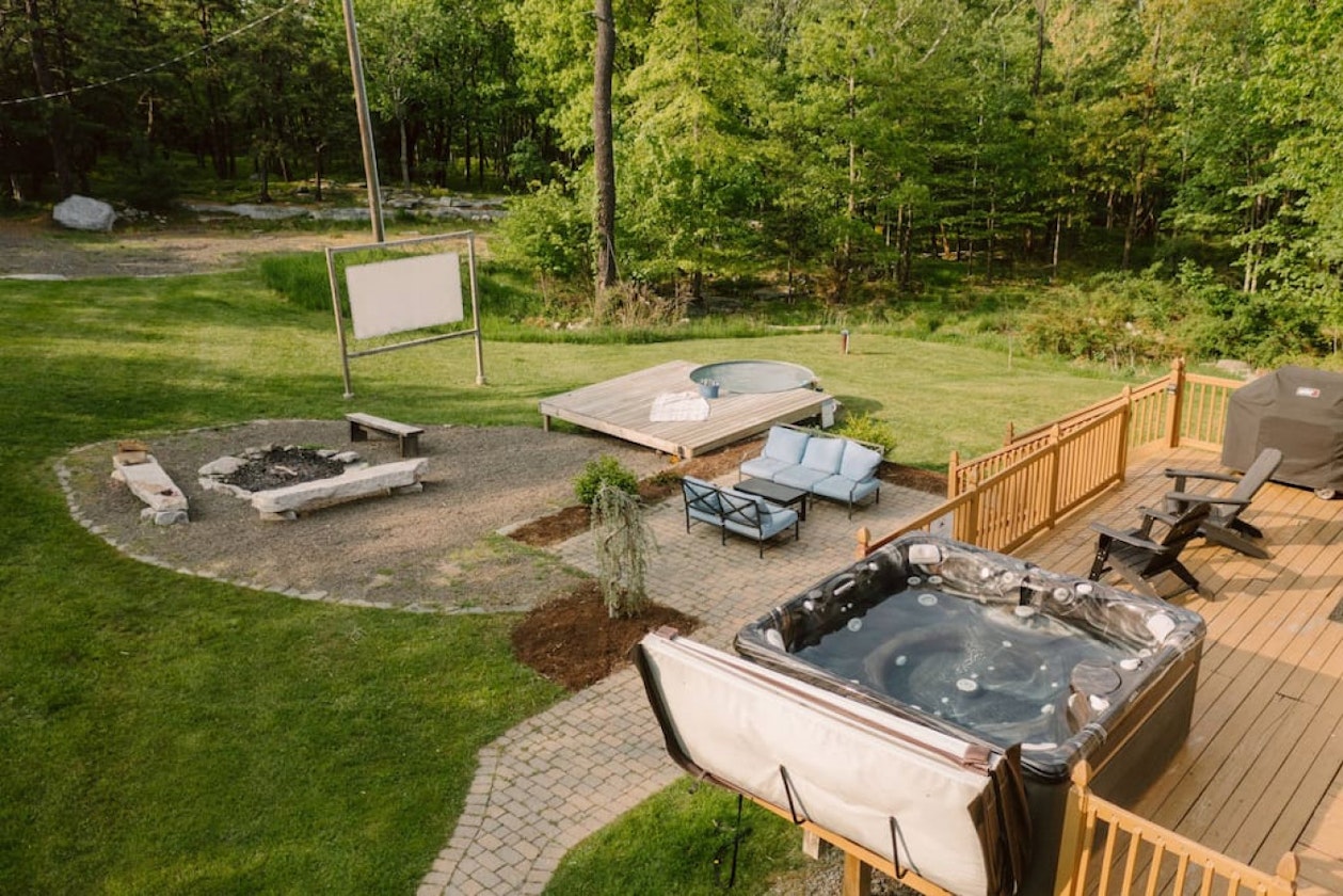 Backyard, hot tub, stock tank pool, firepit, and projector screen for movies